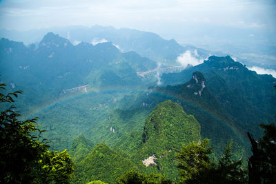 Scenic view of rainbow over mountains against sky