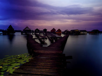 Pier over lake against sky during sunset