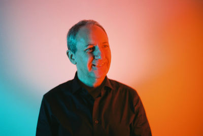 Portrait of young man against orange background