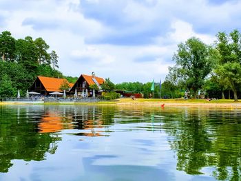 Scenic view of swimming pool by lake and building against sky