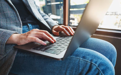 Midsection of woman using laptop