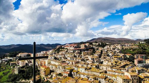 View of cityscape against cloudy sky