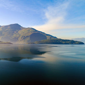 Scenic view of sea and mountains against sky