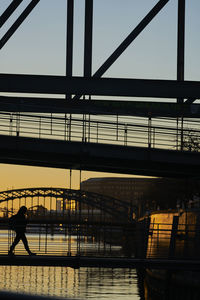 Silhouette people on bridge
