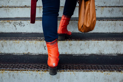 Low section of woman carrying bag on steps