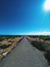 Road amidst landscape against clear blue sky