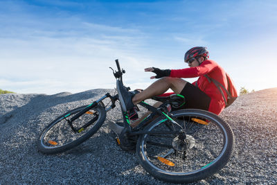 Man riding bicycle on motorcycle against sky