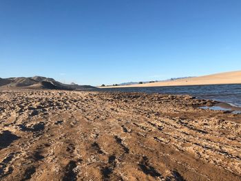 Scenic view of desert against clear blue sky