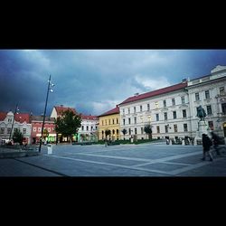 Buildings in city against cloudy sky