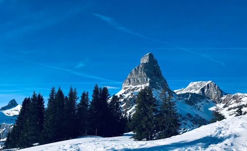 Snow covered mountain against blue sky