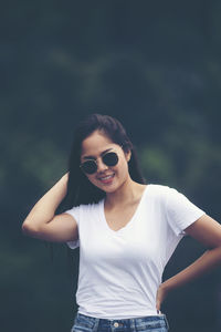 Portrait of young woman wearing sunglasses standing outdoors