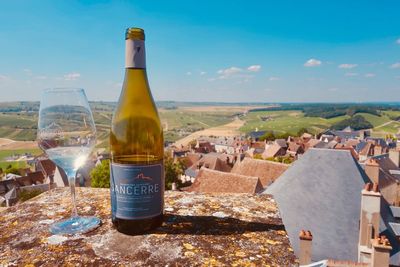 Panoramic shot of bottles and buildings against sky