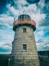 Low angle view of lighthouse against cloudy sky