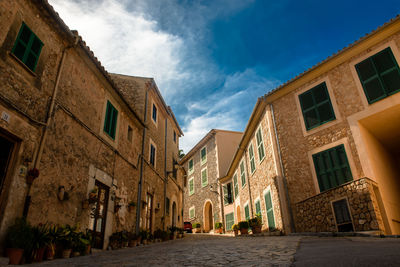 Low angle view of buildings in town against sky