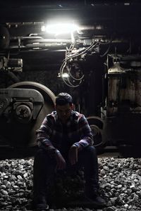 Midsection of man sitting in illuminated nightclub