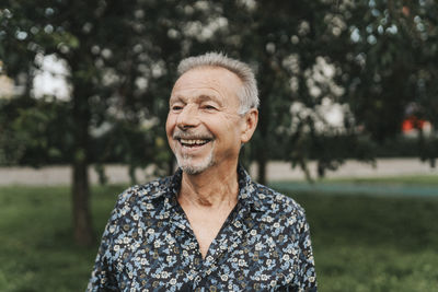 Happy senior man looking away at park