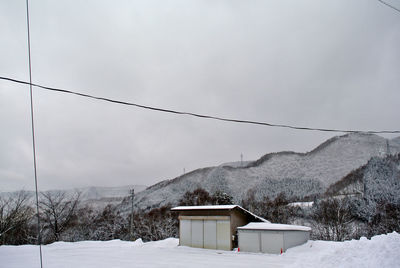 Scenic view of snow covered landscape next to outdoor sheds