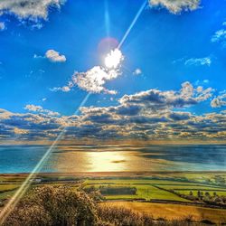 Scenic view of sea against bright sun