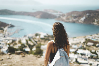 Rear view of woman standing by sea against sky