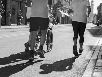 Athletes runners and boy in a wheelchair during sport marathon.