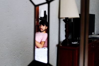 Reflection of man on mirror at home