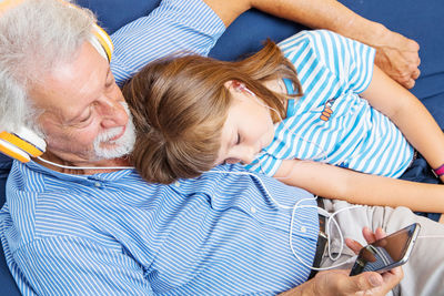 Grandfather and granddaughter listening music