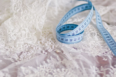 Close-up of tape measure on white dress