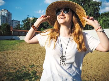 Portrait of smiling young woman wearing sunglasses