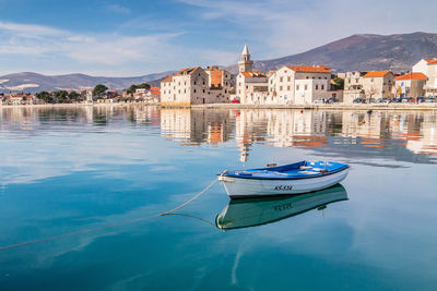 Boats moored on canal by buildings in city
