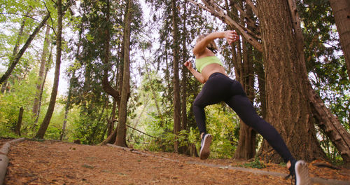 Woman looking at trees in forest