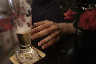 Cropped image of person by beer glass