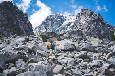 Rear view of person on rock against sky