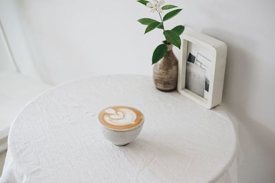 Coffee cup and potted plant on table