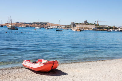 Ship moored on beach against clear sky