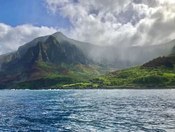 Scenic view of sea and mountains against sky