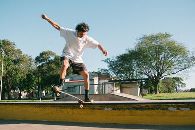 Skateboarder sliding in skate park