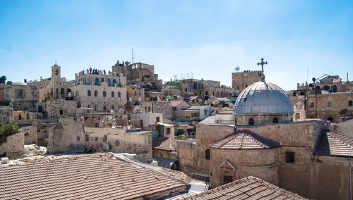 Church and residential buildings in city against sky