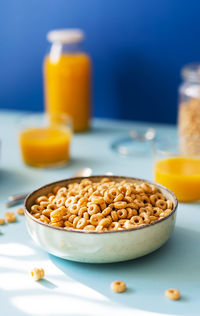 Breakfast concept with cold cereals and orange juice on blue background