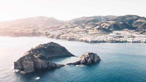 Scenic view of sea and mountains against clear sky