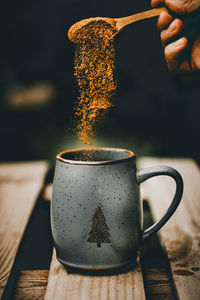 Cropped hand of person pouring coffee on table