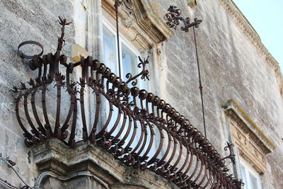 Low angle view of ornate hanging on wall of old building