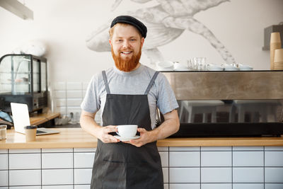 Portrait of young man standing in kitchen