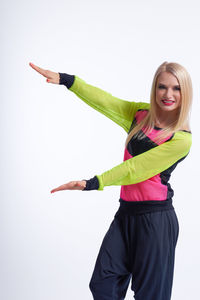 Portrait of young woman standing against white background