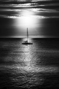 Sailboat sailing on sea against sky during sunset