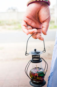 Cropped image of woman holding old-fashioned lantern