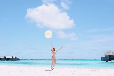 Full length of woman walking on beach against sky