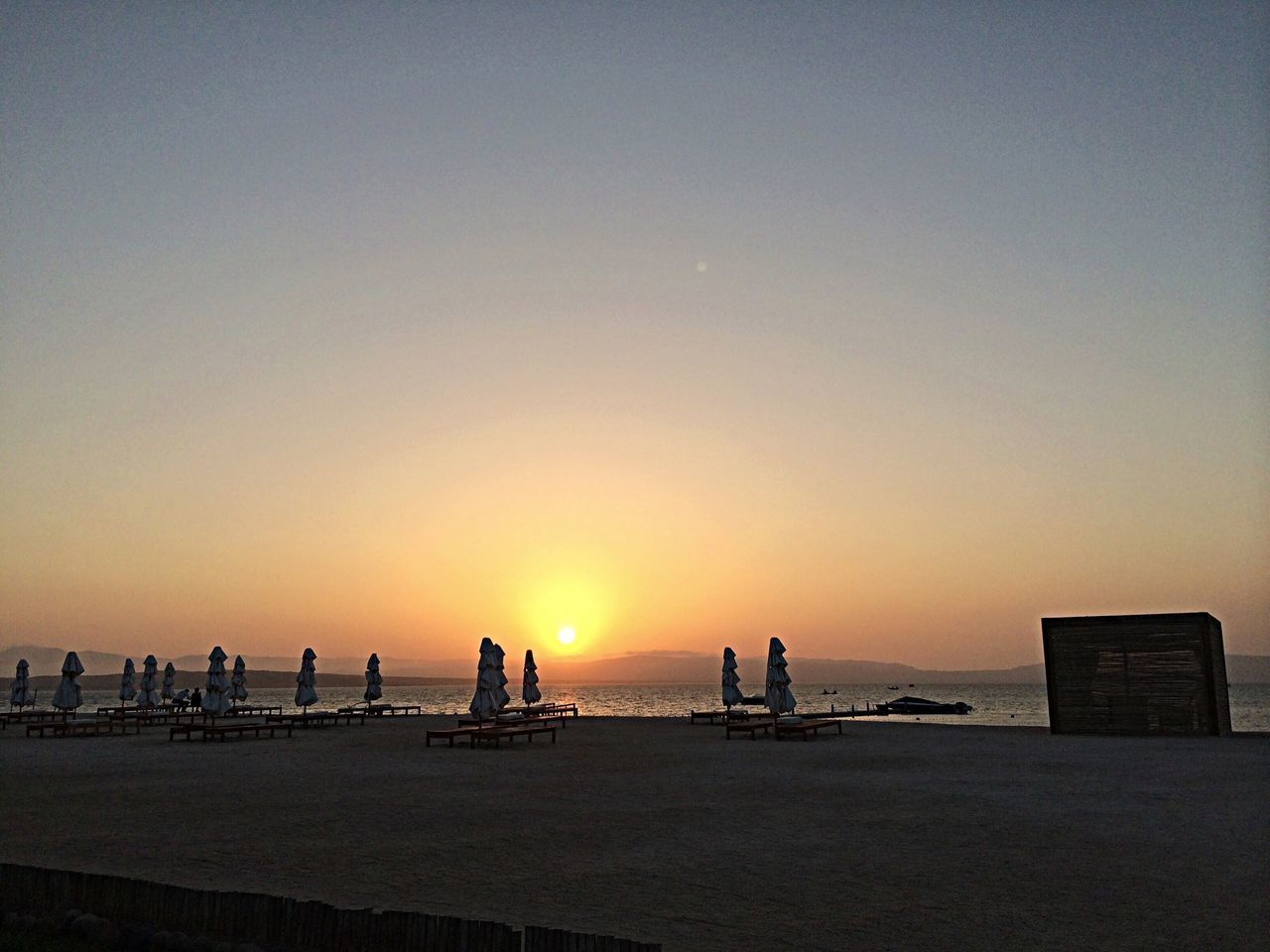 sunset, sea, silhouette, orange color, water, copy space, beach, scenics, horizon over water, tranquil scene, clear sky, beauty in nature, tranquility, sun, nature, idyllic, incidental people, sky, shore, pier