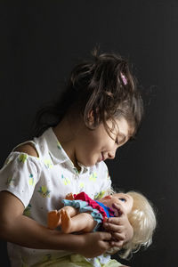 Close-up of cute baby girl over black background