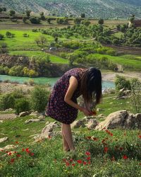 Rear view of woman standing on field