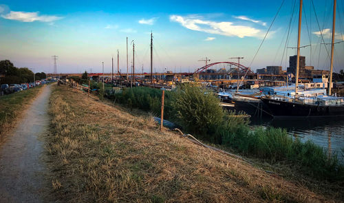 Boats moored in canal at sunset